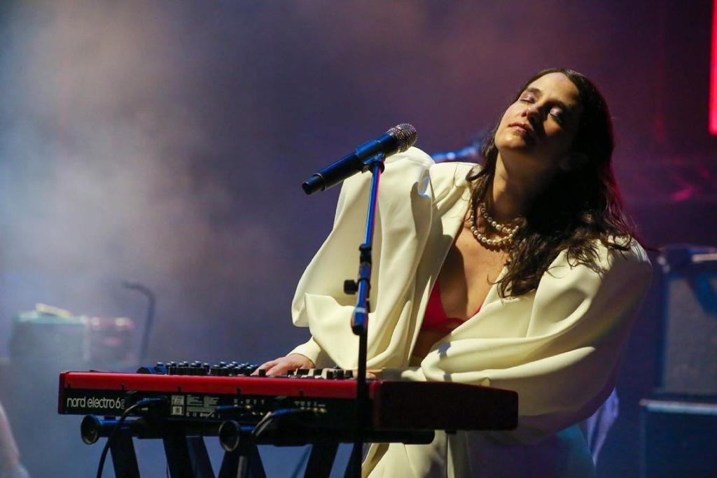 Ximena Sarñana in concert wearing white balloon style white jacket.